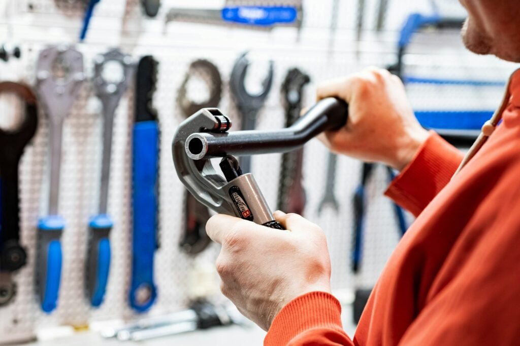 A plumber choosing a pipe wrench from a tool wall